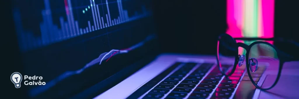 Imagem ilustrando notebook com óculos em cima e na tela do notebook alguns gráficos para indicar tendências do mercado de tecnologia