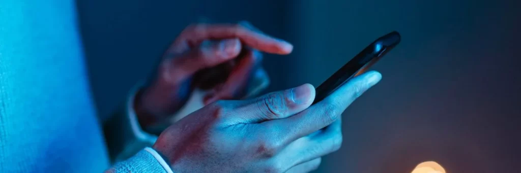 Pessoa mexendo no celular para indicar aplicativos