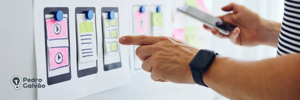 Telas de aplicativo mobile em papel grudadas em um board de kanban na parede mostrando o desenvolvimento mobile